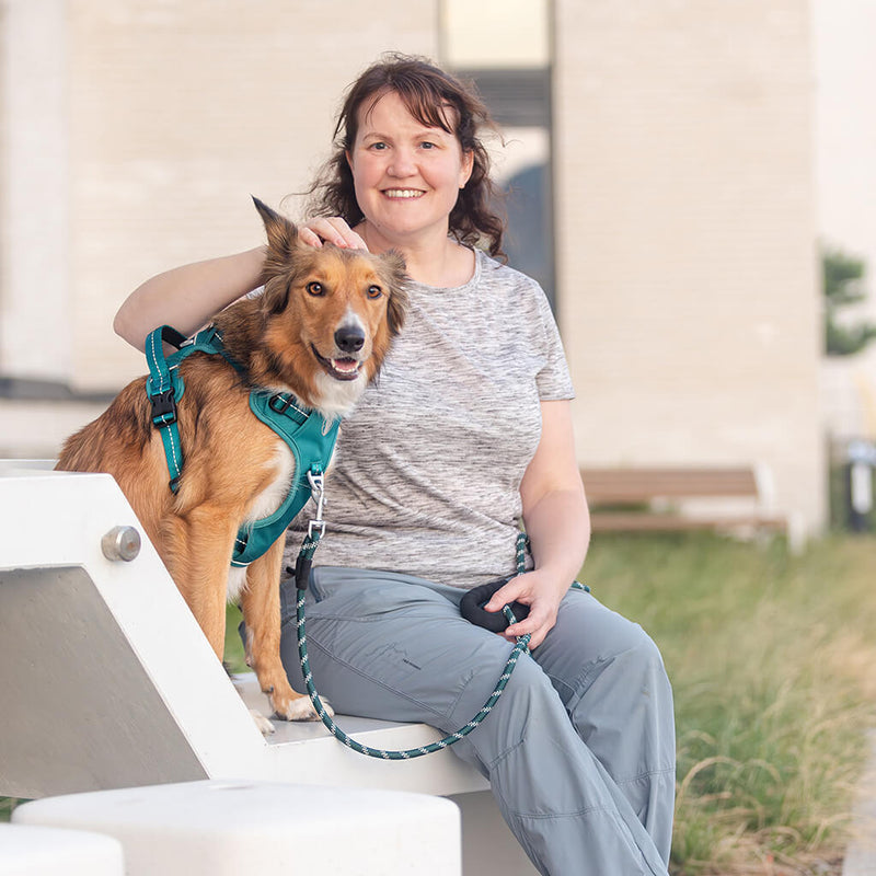 A woman walking her small dog on a slack leash